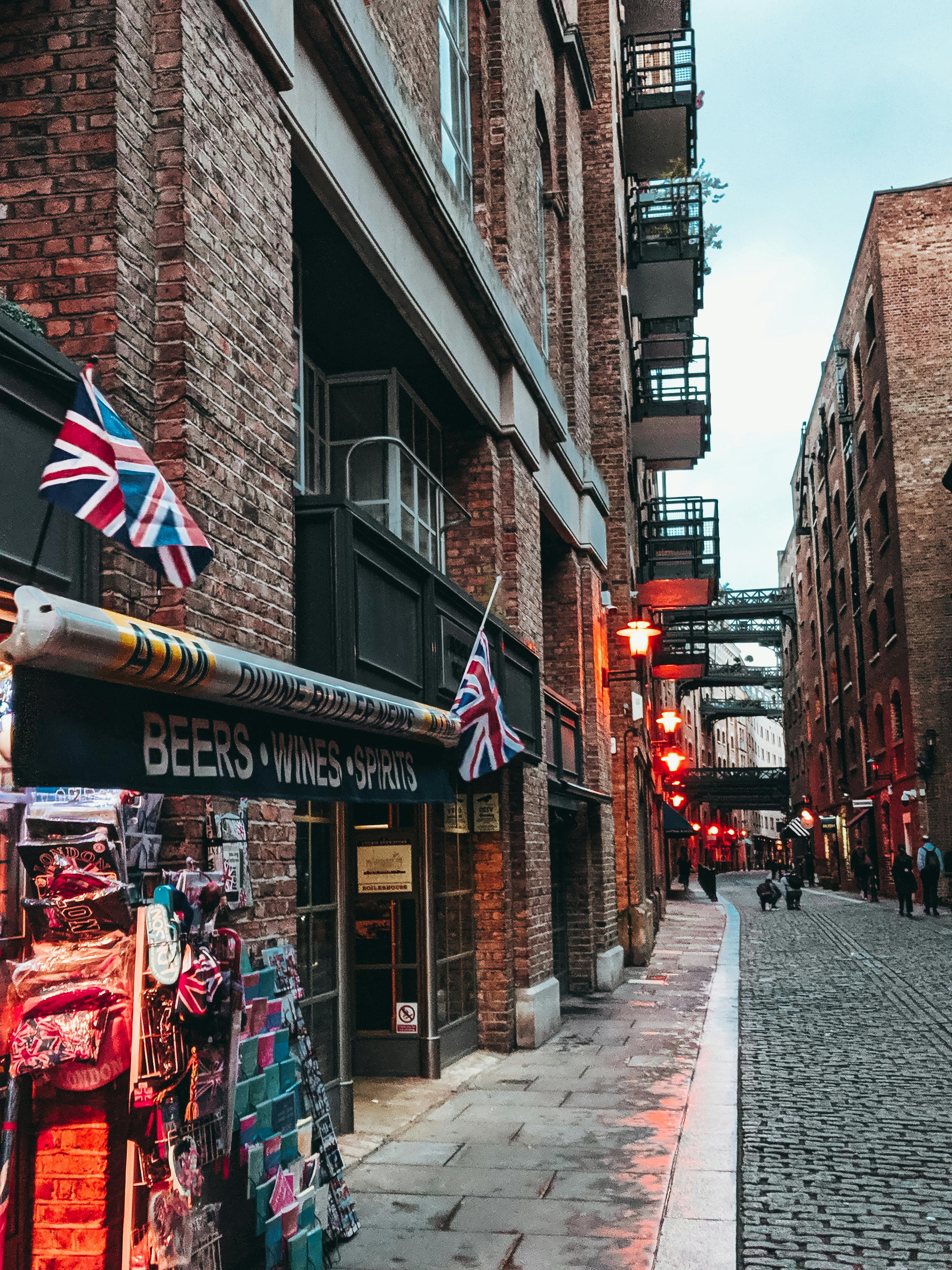Explore a picturesque brick alleyway adorned with British flags in bustling central London.