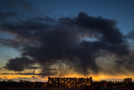 A stunning city skyline at twilight with dramatic clouds and glowing windows.