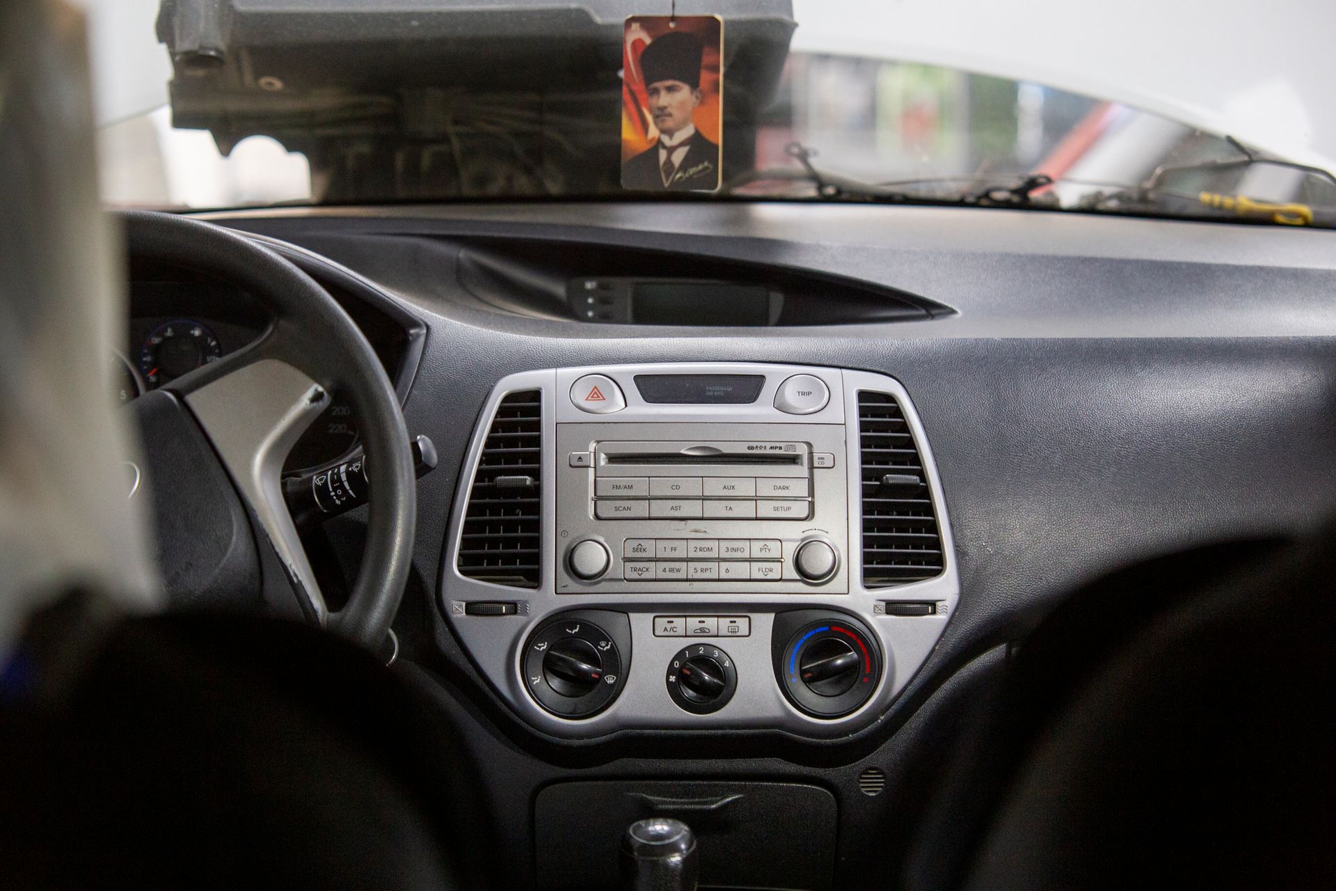 Close-up of a car's dashboard featuring stereo controls and a decorative photo.