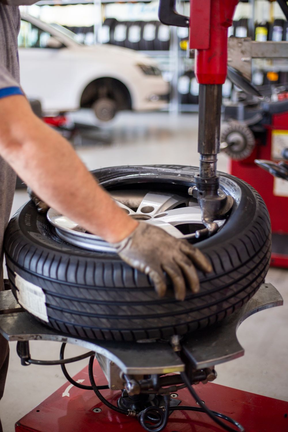 Mechanic mounting a tire on a wheel in a workshop