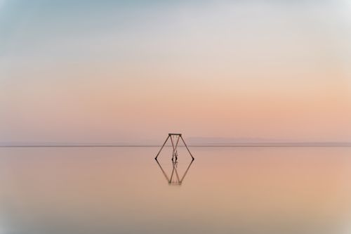 Free A serene swing set in still waters at sunset, reflecting tranquility and solitude. Stock Photo