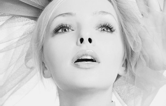 Close-up black and white portrait of a woman with an expressive gaze and headpiece, captured in Kyiv.