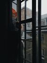Unrecognizable Woman Standing on a Window Sill