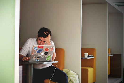 Man in White Shirt Using Macbook Pro