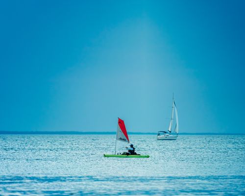 Free Picturesque seascape with sailing boats floating on rippling water of sea under cloudless blue sky in daytime Stock Photo