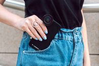 Person Putting a Smartphone in Pocket