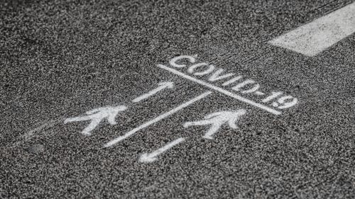 Free From above COVID 19 warning inscription about social distance on asphalt pavement on street Stock Photo