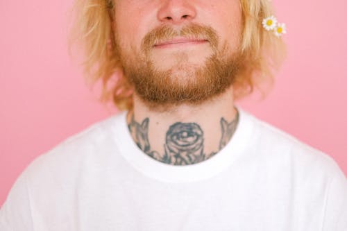 Free Crop anonymous male with blond short hair and beard smiling while standing on pink background Stock Photo