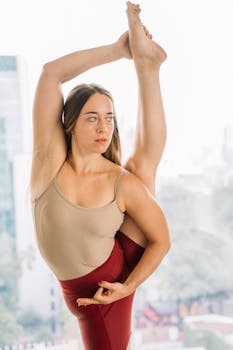 A woman showcasing flexibility with an impressive yoga pose indoors.