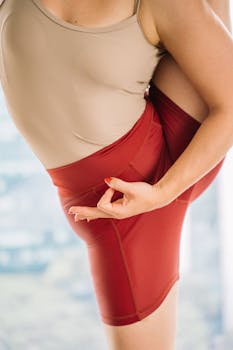 Close-up of a woman practicing an advanced yoga pose indoors, showcasing flexibility.