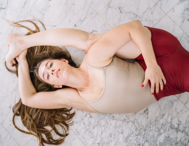 Woman Lying On The Floor Stretching Her Legs