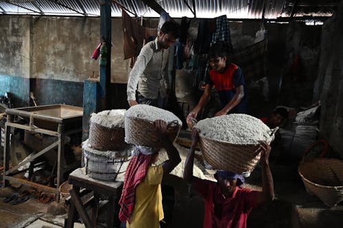 Men Working Together Carrying and Holding Brown Woven Baskets