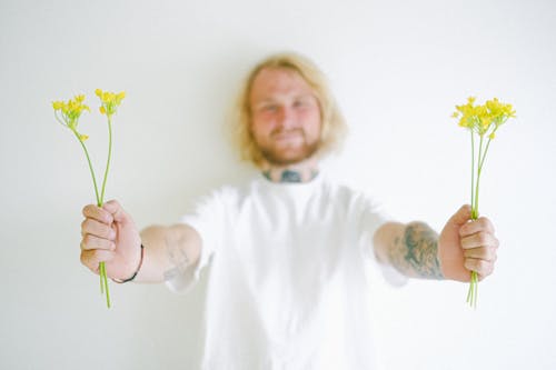 Free Smiling unshaven man with colorful blossoming flowers Stock Photo