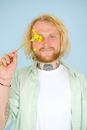 Content unshaven man covering eye with yellow flower
