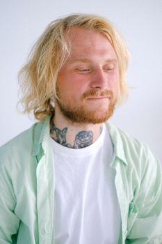 一名身上有动物纹身的成年男性，在白天低头思考着剃光头