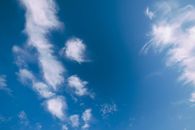 From below of white clouds floating over blue sky in sunny summer day