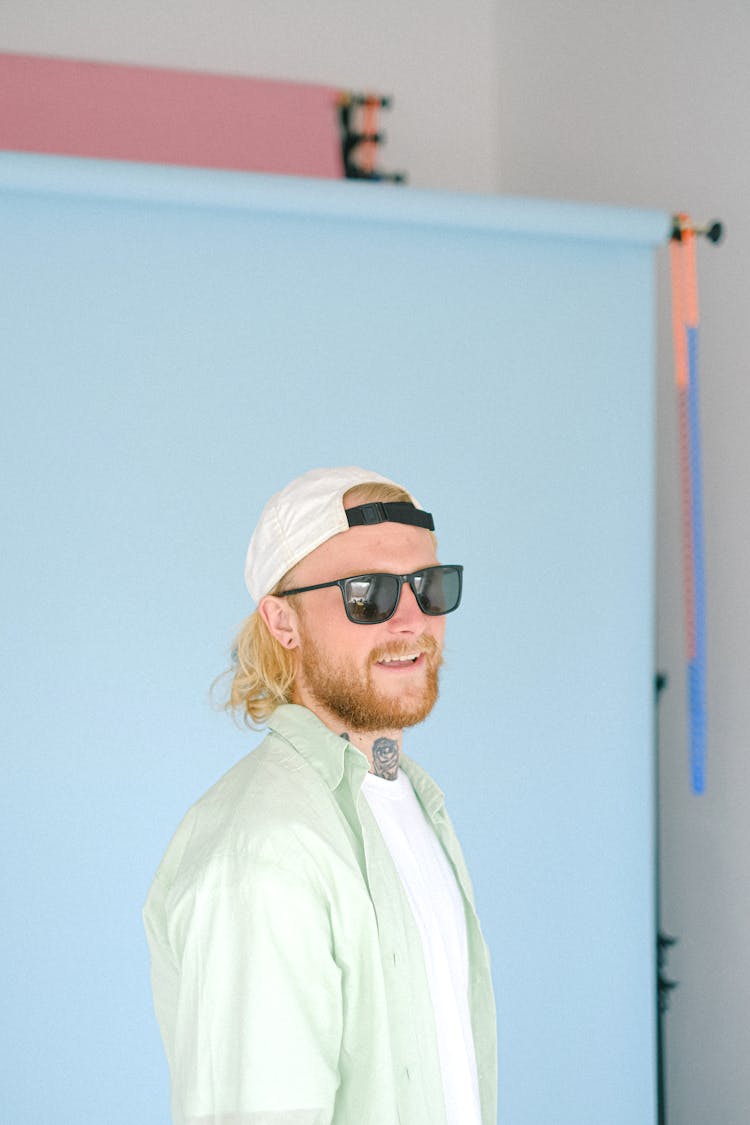 Smiling Bearded Man Near Blue Stand In Photo Studio