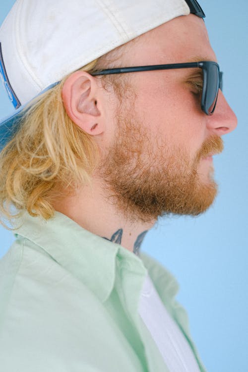 Crop unshaven man in sunglasses on blue background