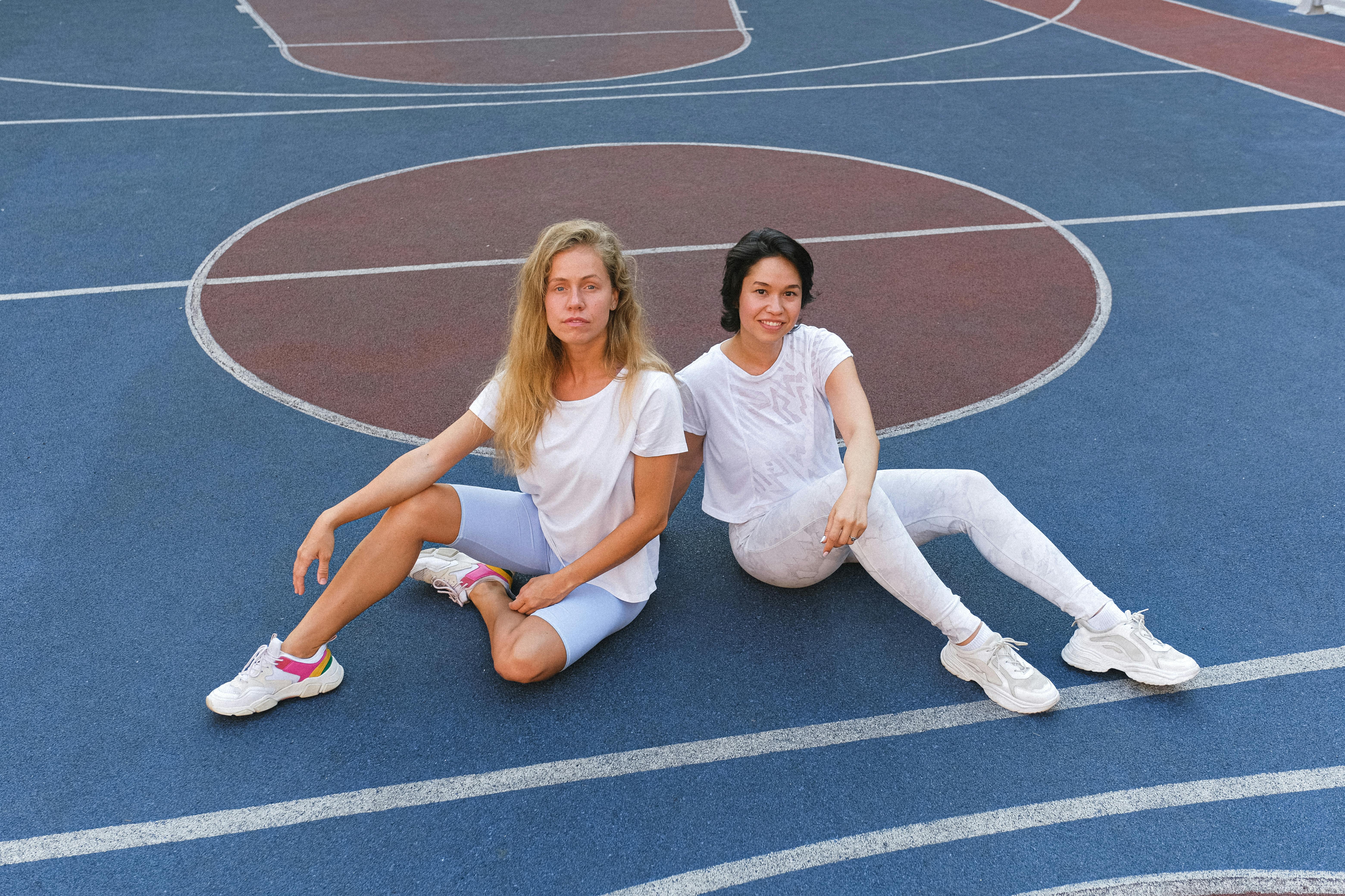 young women resting on floor after sport training together