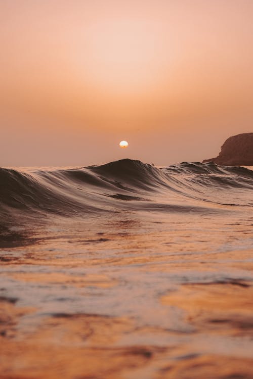 Ocean Waves Crashing on Shore During Sunset