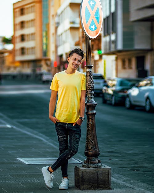 A Man Leaning on Road Sign