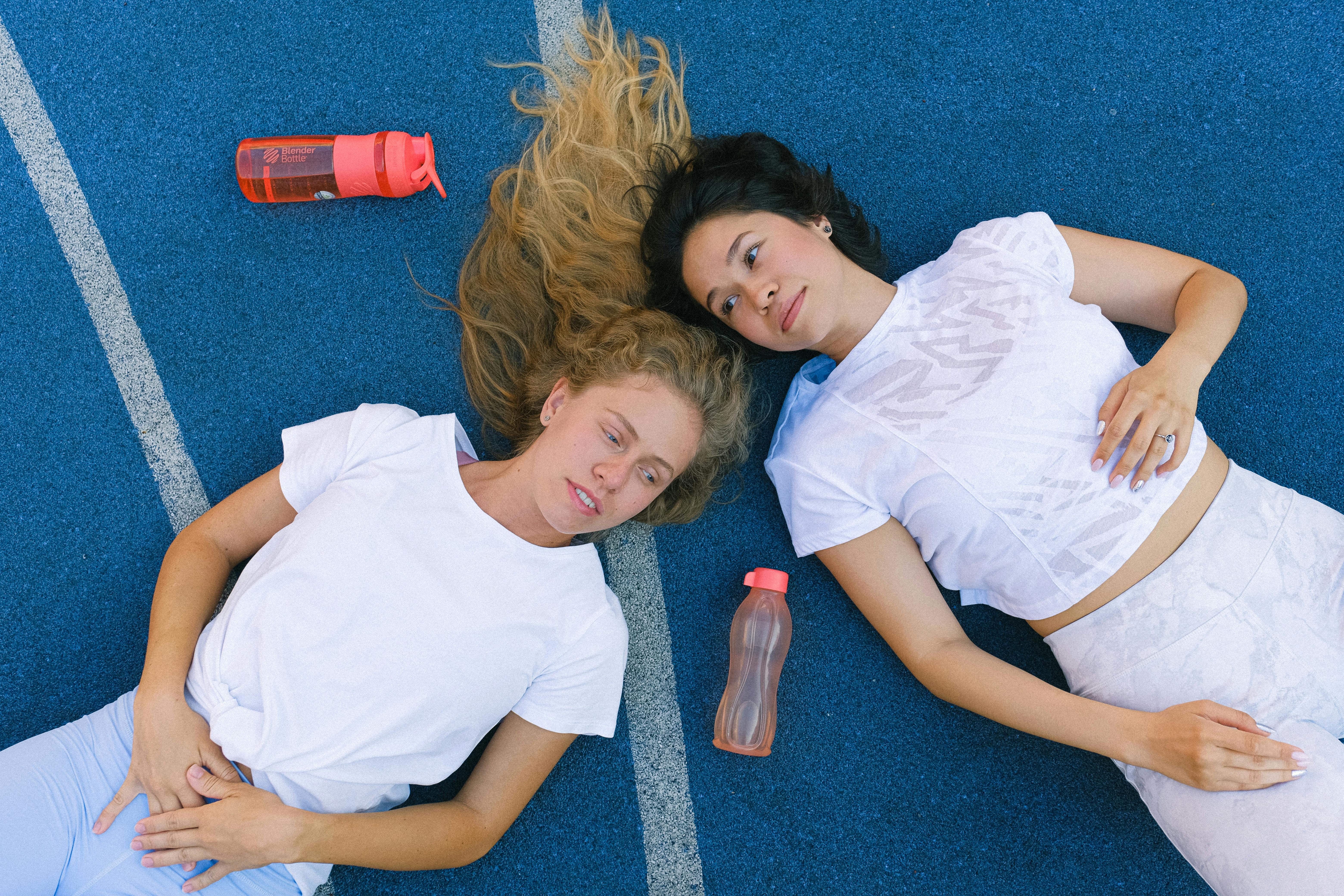 young female athletes having break during workout in sport club