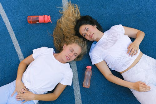 Young female athletes having break during workout in sport club