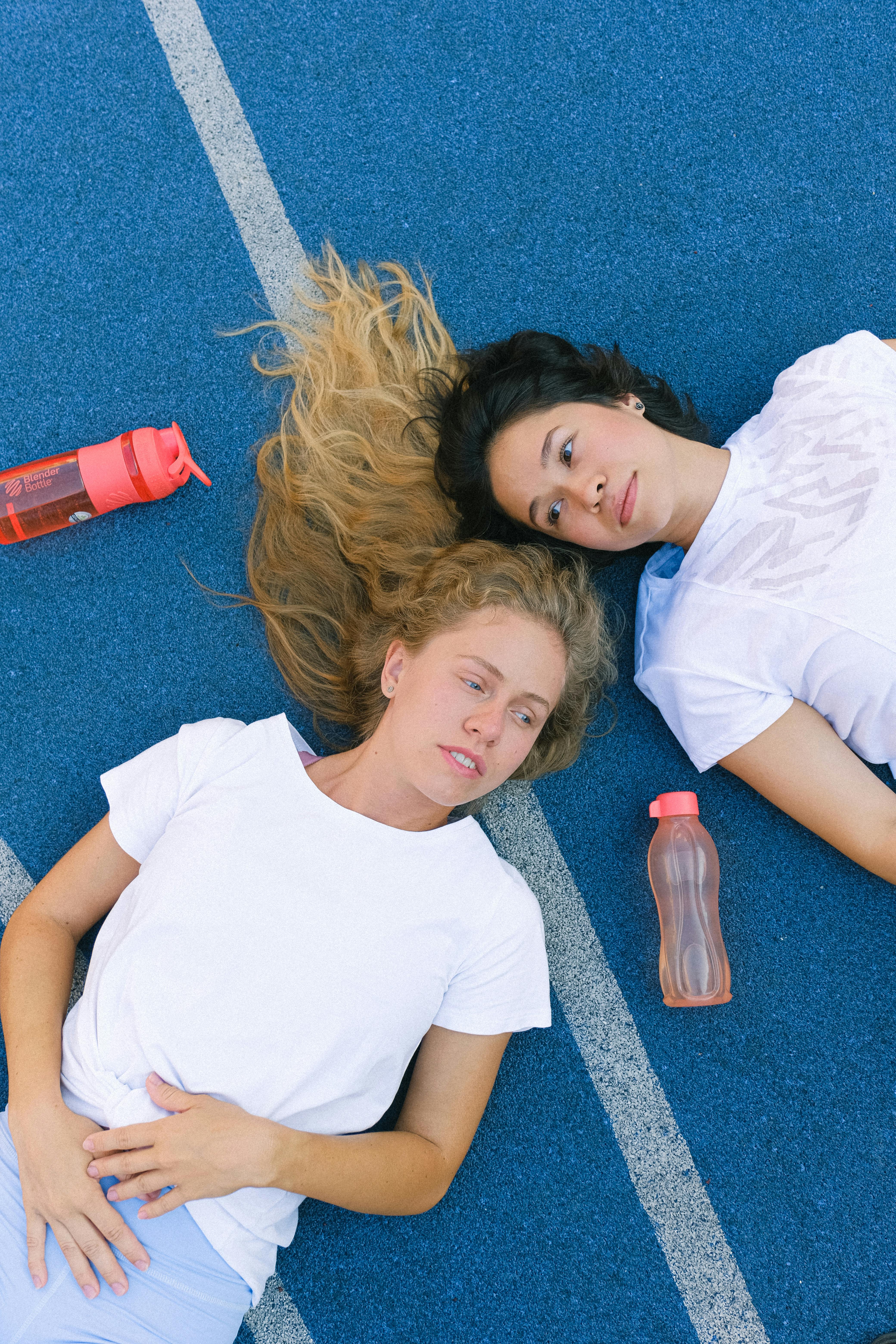 tired and satisfied young women relaxing on floor after training