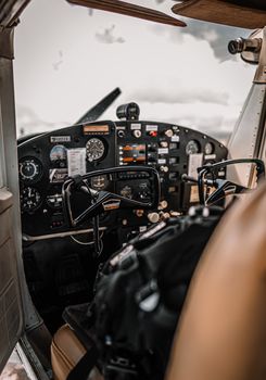 Control panel and yokes of modern light aircraft parked on aerodrome under cloudy sky
