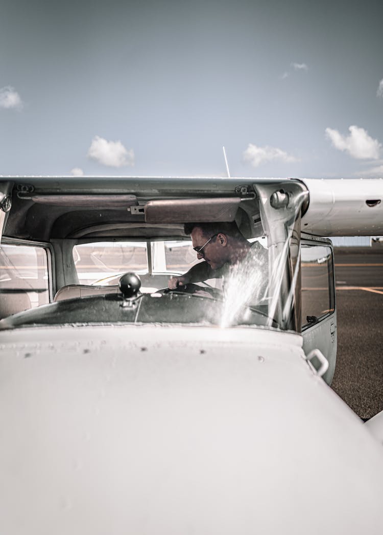 Young Man Sitting In Contemporary Two Seat Aircraft On Aerodrome