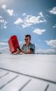 Young man pouring fuel into aircraft tank against blue sky