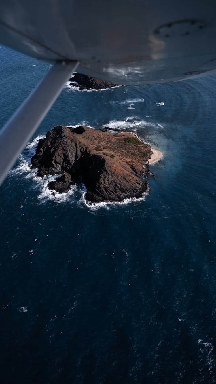 Volcanic Island With Sandy Beach In Blue Sea