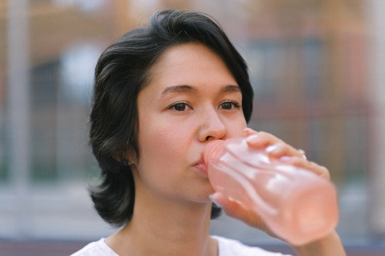 Female Drinking Water On Sports Ground