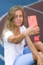 Woman taking selfie on cellphone on court