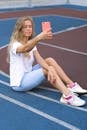 Female using phone on sports ground