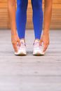 Crop unrecognizable sportswoman stretching and bending down in gym