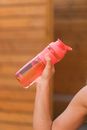 Crop unrecognizable person drinking water from reusable bottle