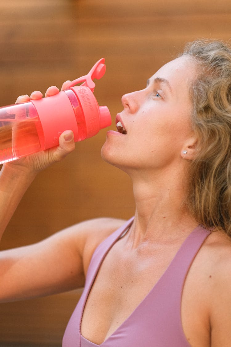 Crop Tired Sportswoman Drinking Water During Training