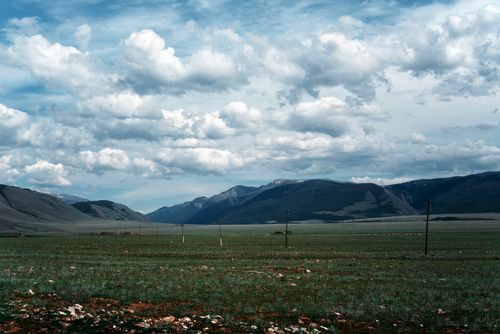 Free Expansive mountain view under a beautiful blue sky with white clouds in a serene landscape. Stock Photo