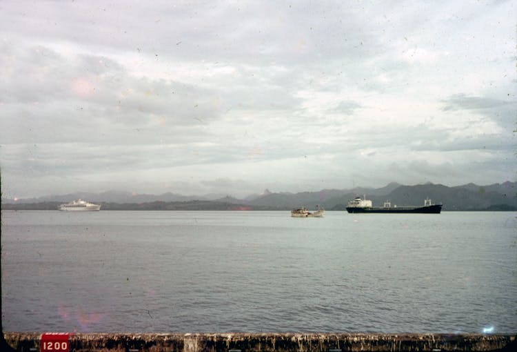 Vessels In A Body Of Water Under Cloudy Sky