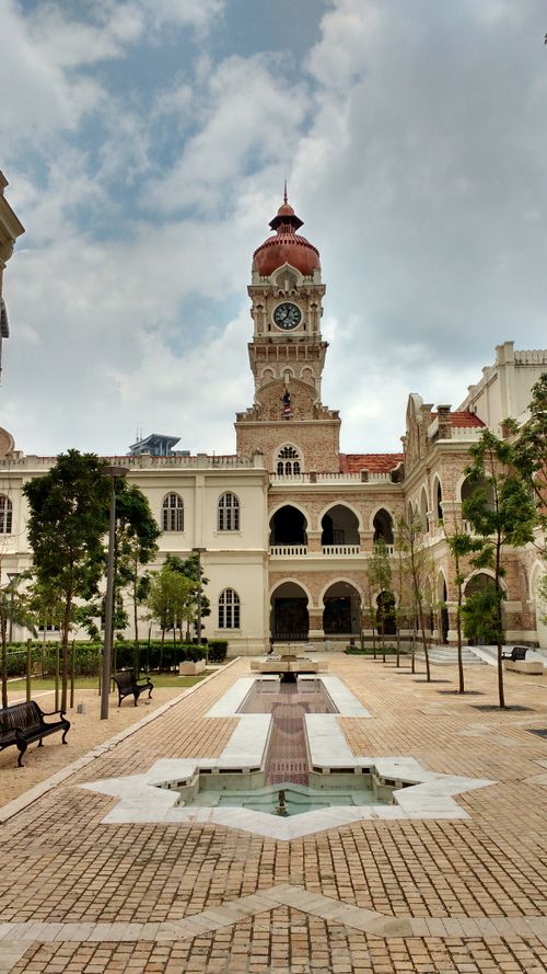 Free View of the iconic clock tower in Kuala Lumpur with blue skies and white clouds. Stock Photo