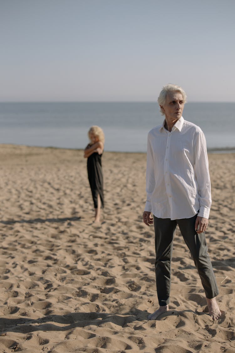 A Man In White Long Sleeves Standing On Brown Sand