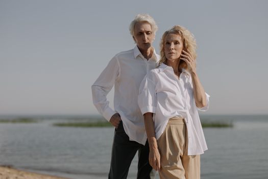 一对年长夫妇在阳光明媚的海滩上享受着宁静的时刻