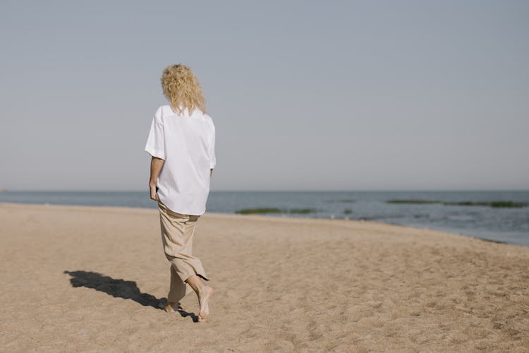 A Woman Walking On The Beach 