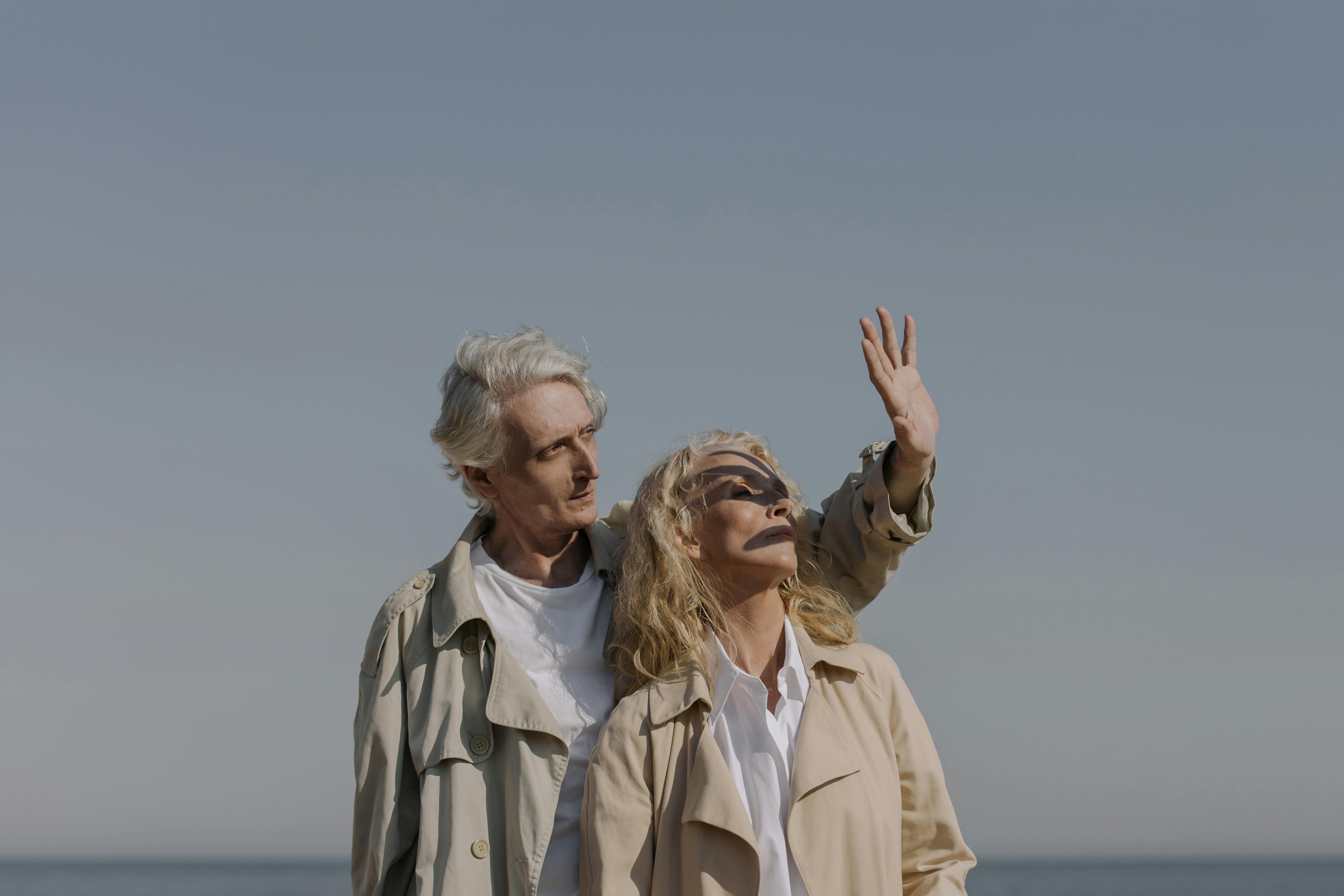 2 women in white dress shirt standing on beach