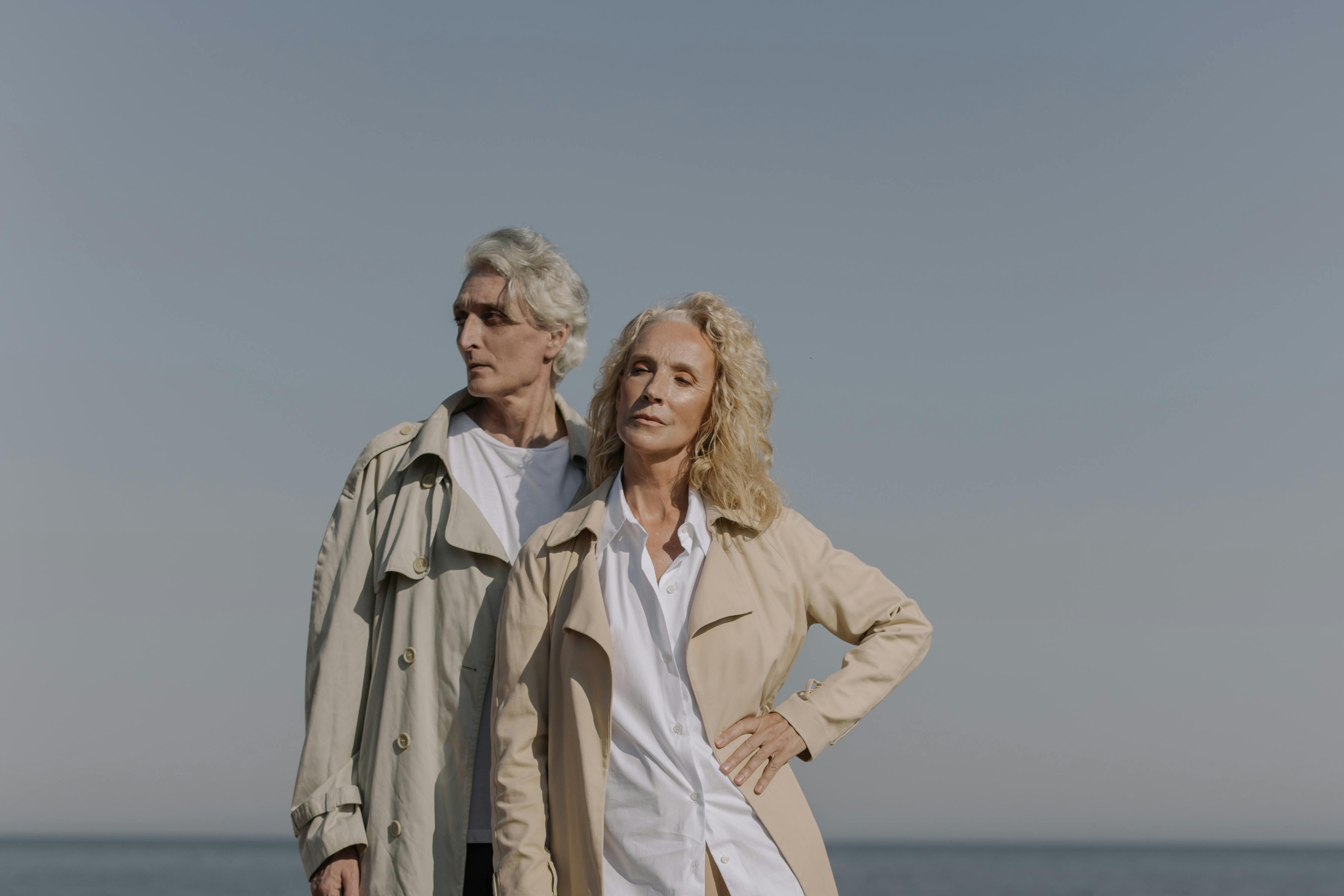 woman in brown coat standing near body of water