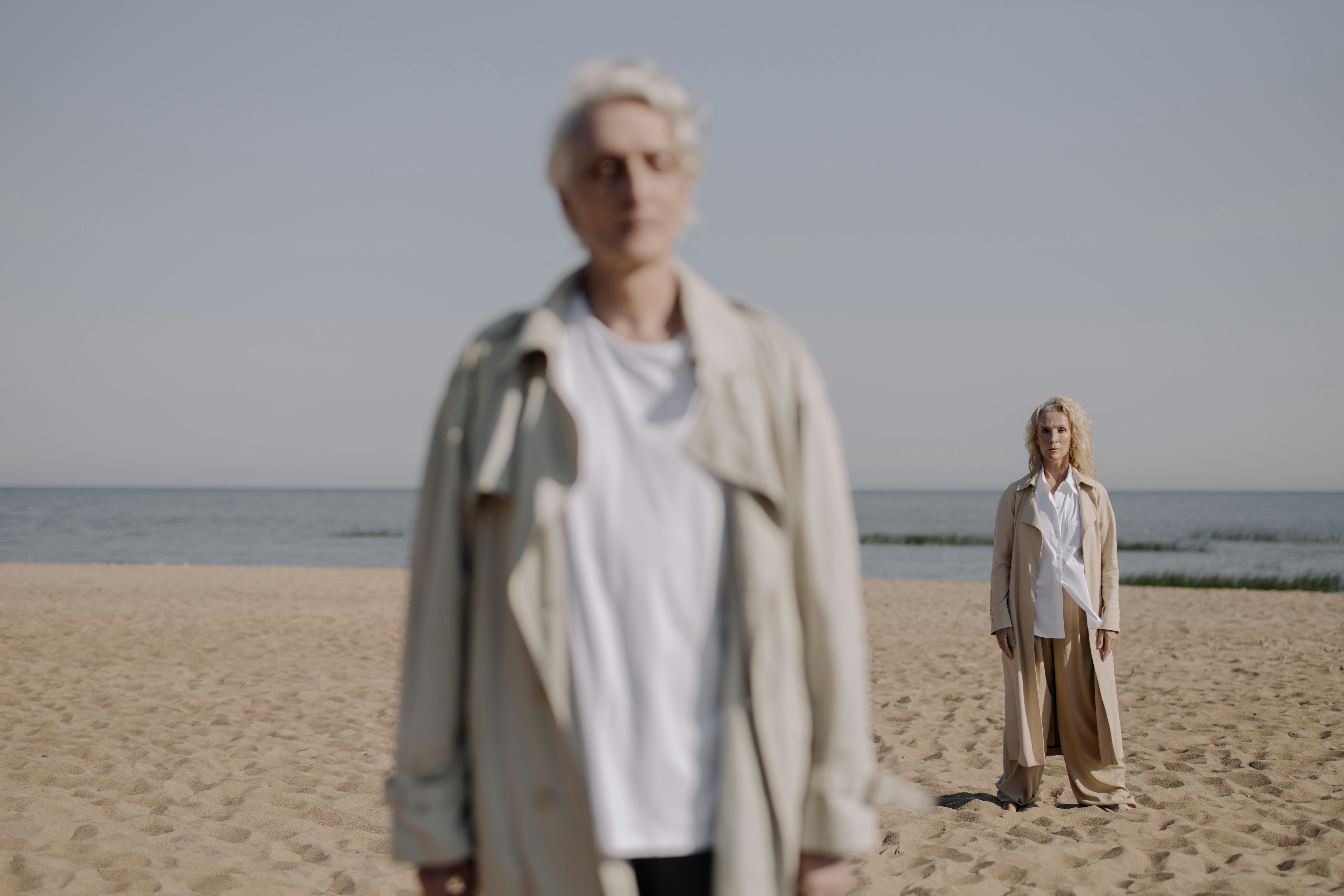 man in white dress shirt standing on beach