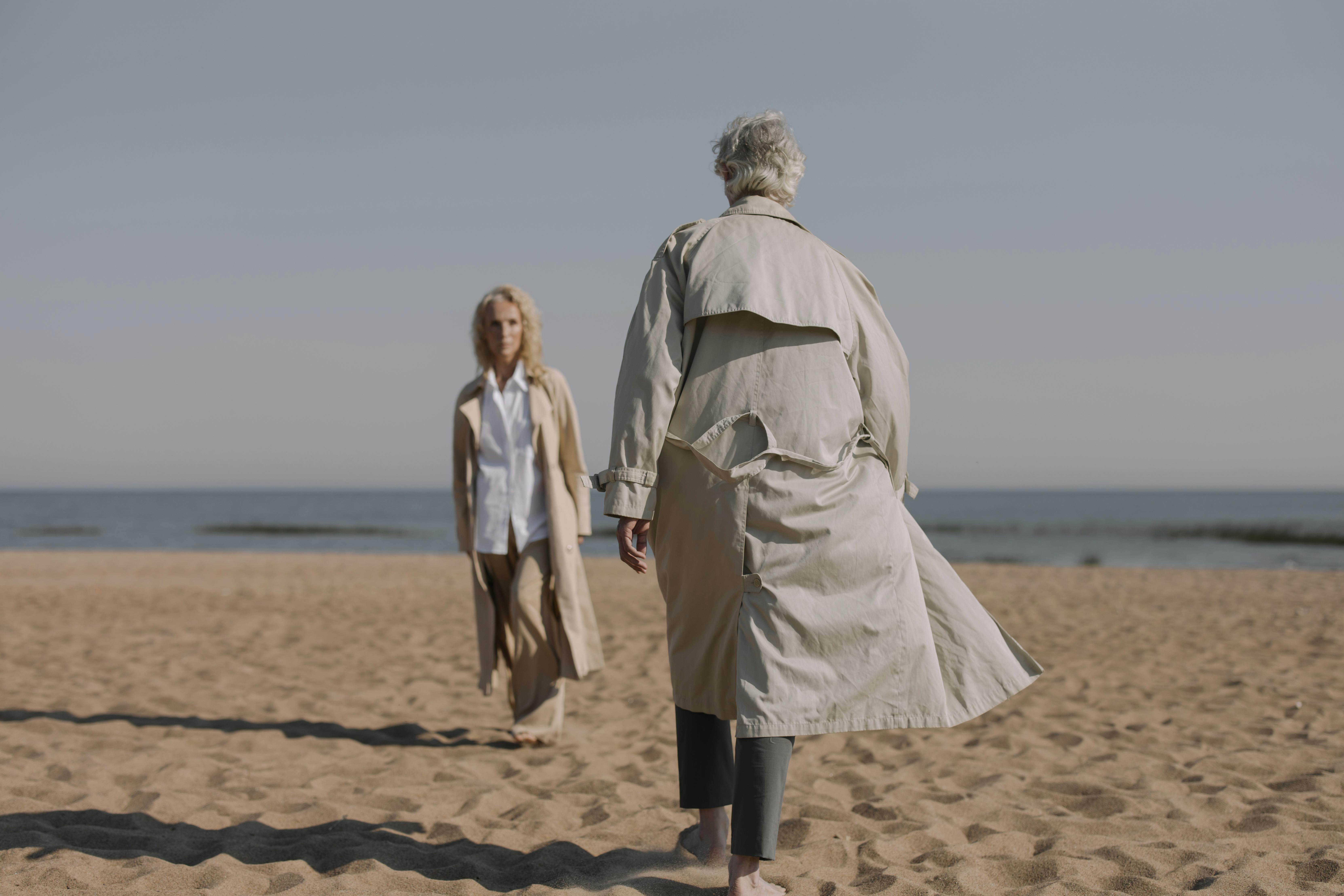 man and woman standing on brown sand