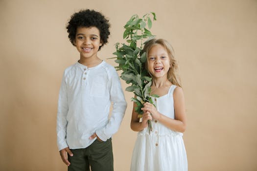 孩子们在中性背景下与新鲜的绿色植物愉快地合影，脸上带着微笑