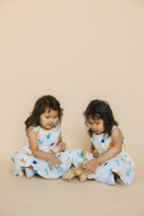 Two Girls Sitting with Chickens